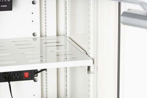White metal shelving unit with power strip and Canon camera in the background