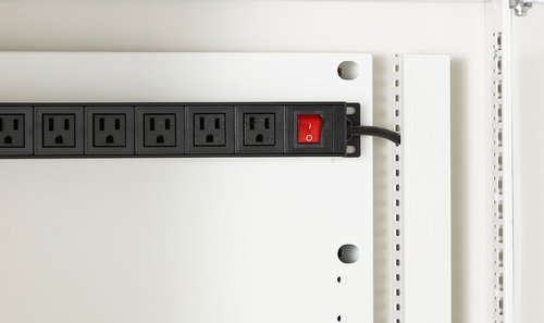 Power strip with multiple outlets on a white wall panel
