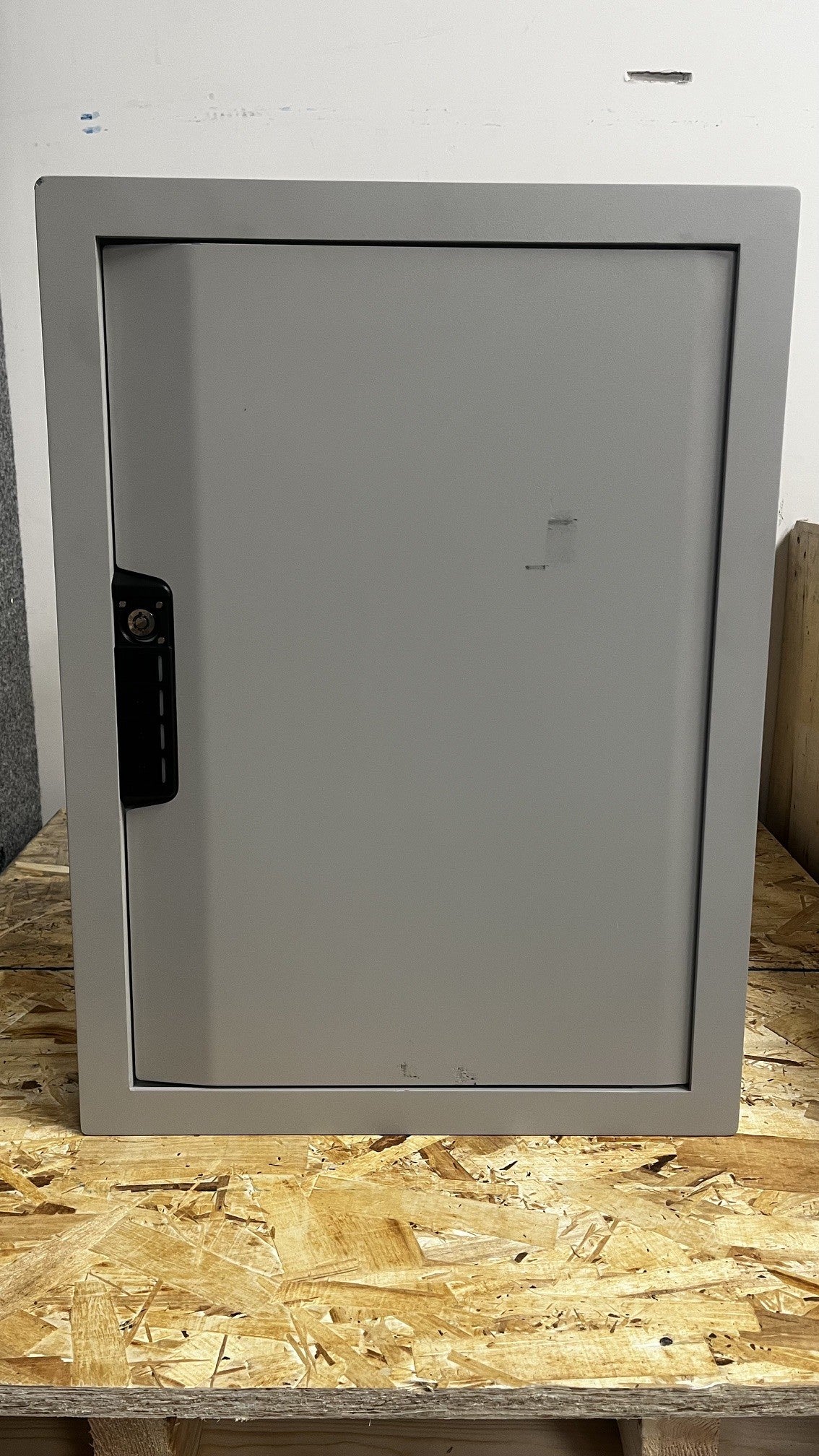 View of the front of the safe, it has a few scratches on the door. It also is missing the lid to key access hole. 
