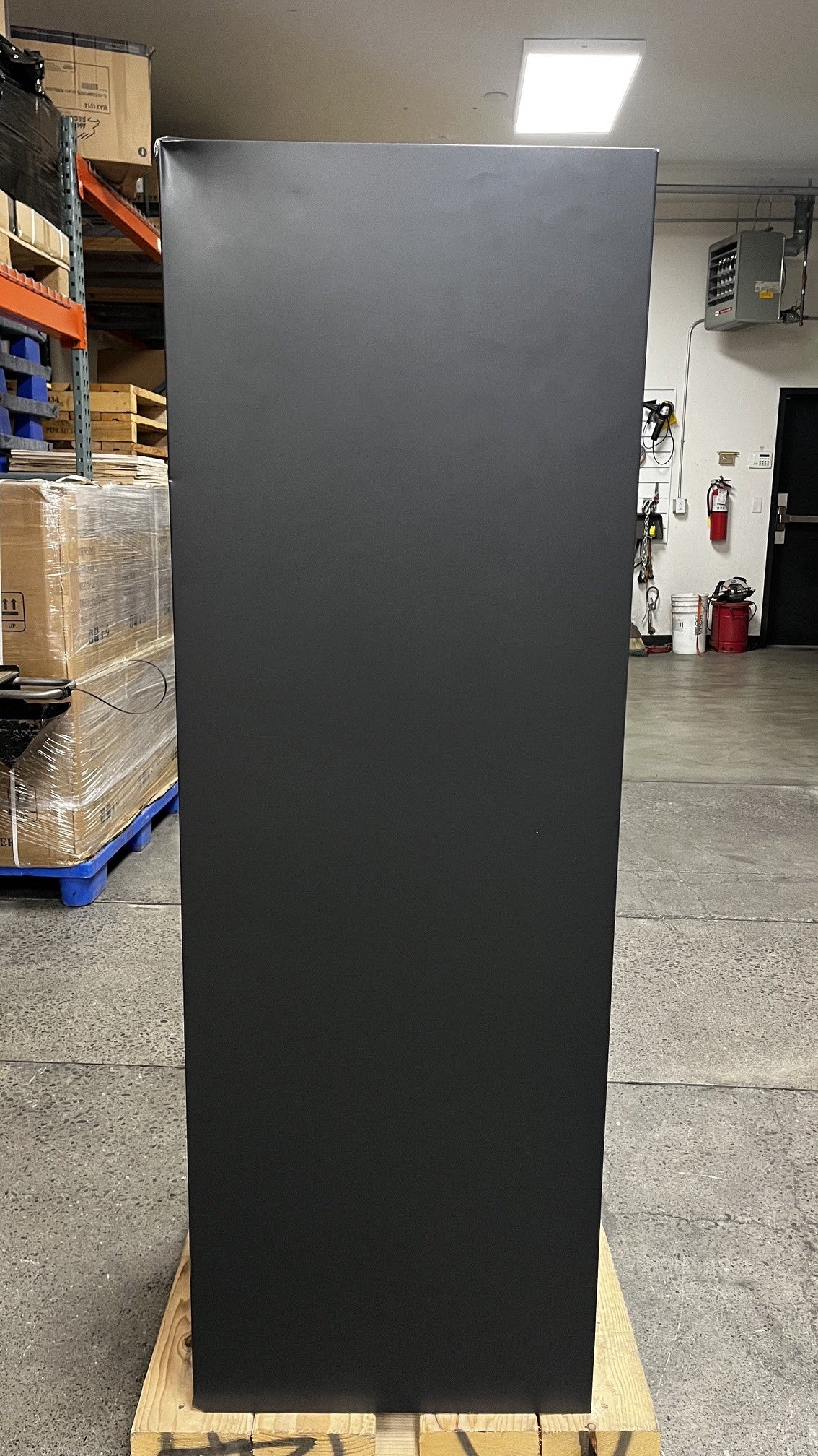 View of the left side of the safe. The top left corner has a dent. 