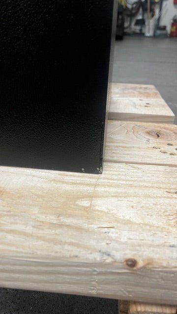 View of a small paint chip on the back lower corner of the safe. 