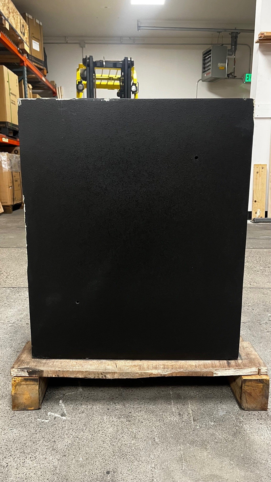 Back side view of the safe. The top edge and the left edge have scratches. The safe comes with two predrilled holes to pass power into the safe. 