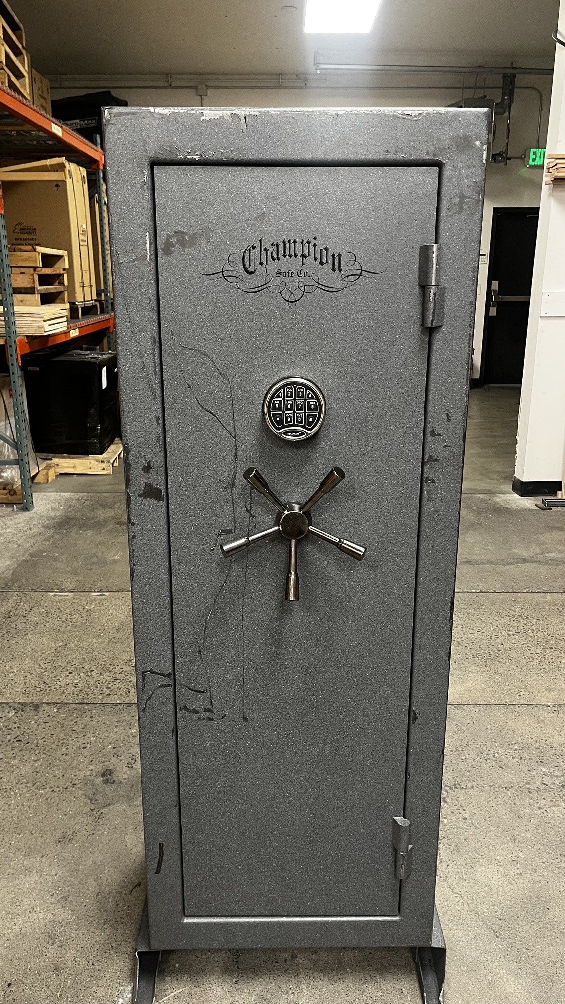 Front view of the safe, the safe has a significant number of scratches throughout the front side. 
