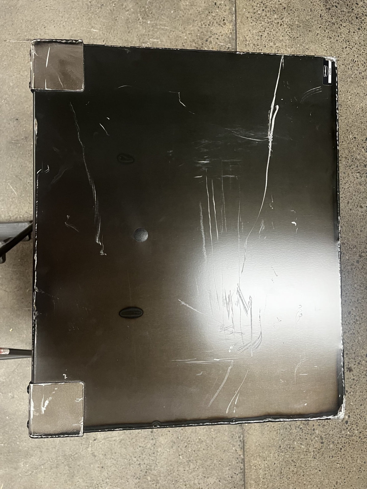 View of the top of the safe. It has scratches throughout the whole top. 