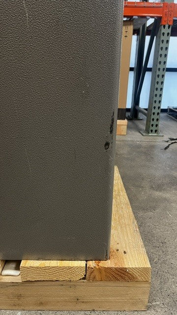 View of the scratches and paint chips alongside the edge of the safe. 