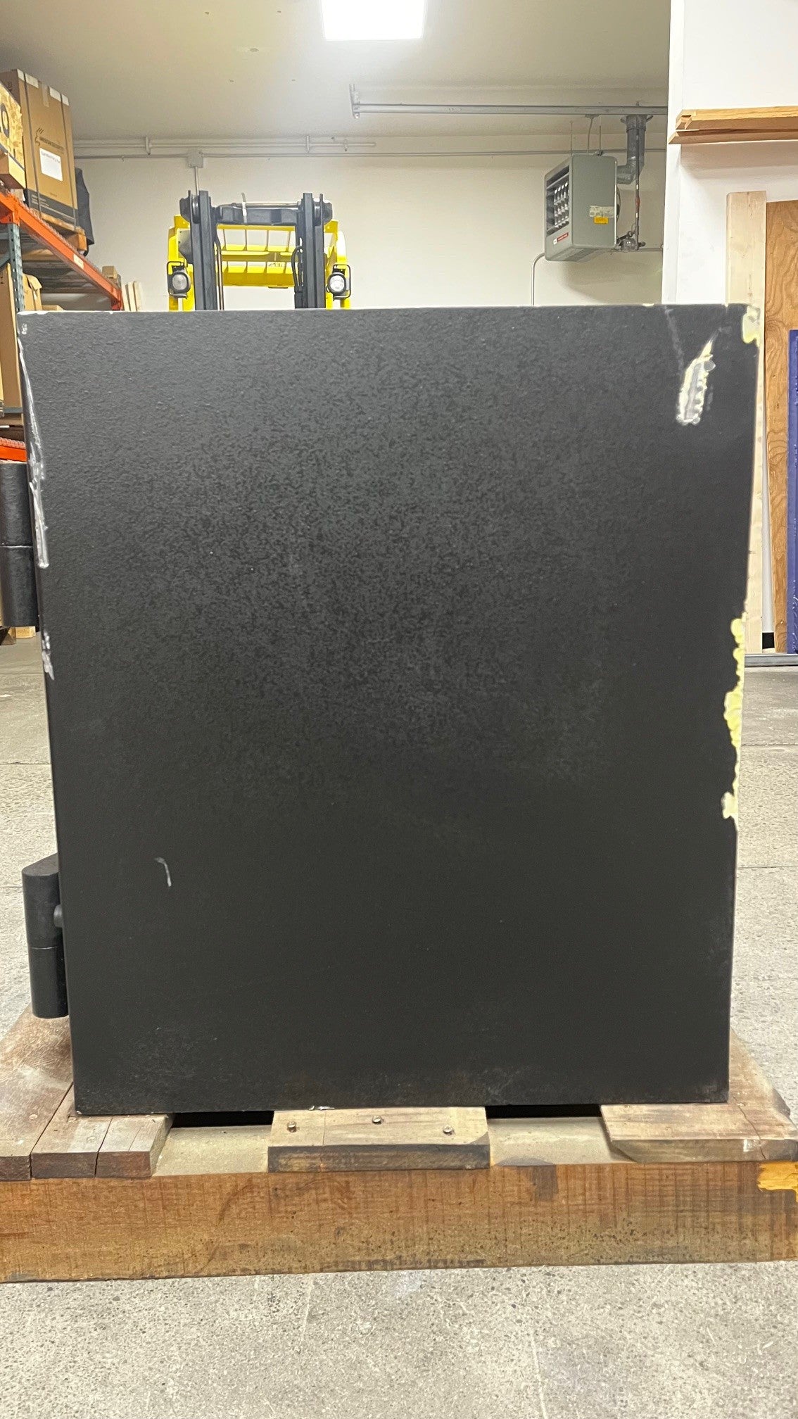 View of the right side of the safe. The edges on the left and right of the safe have some scratches. The of the safe also has a scratch that is close to the right top corner. 