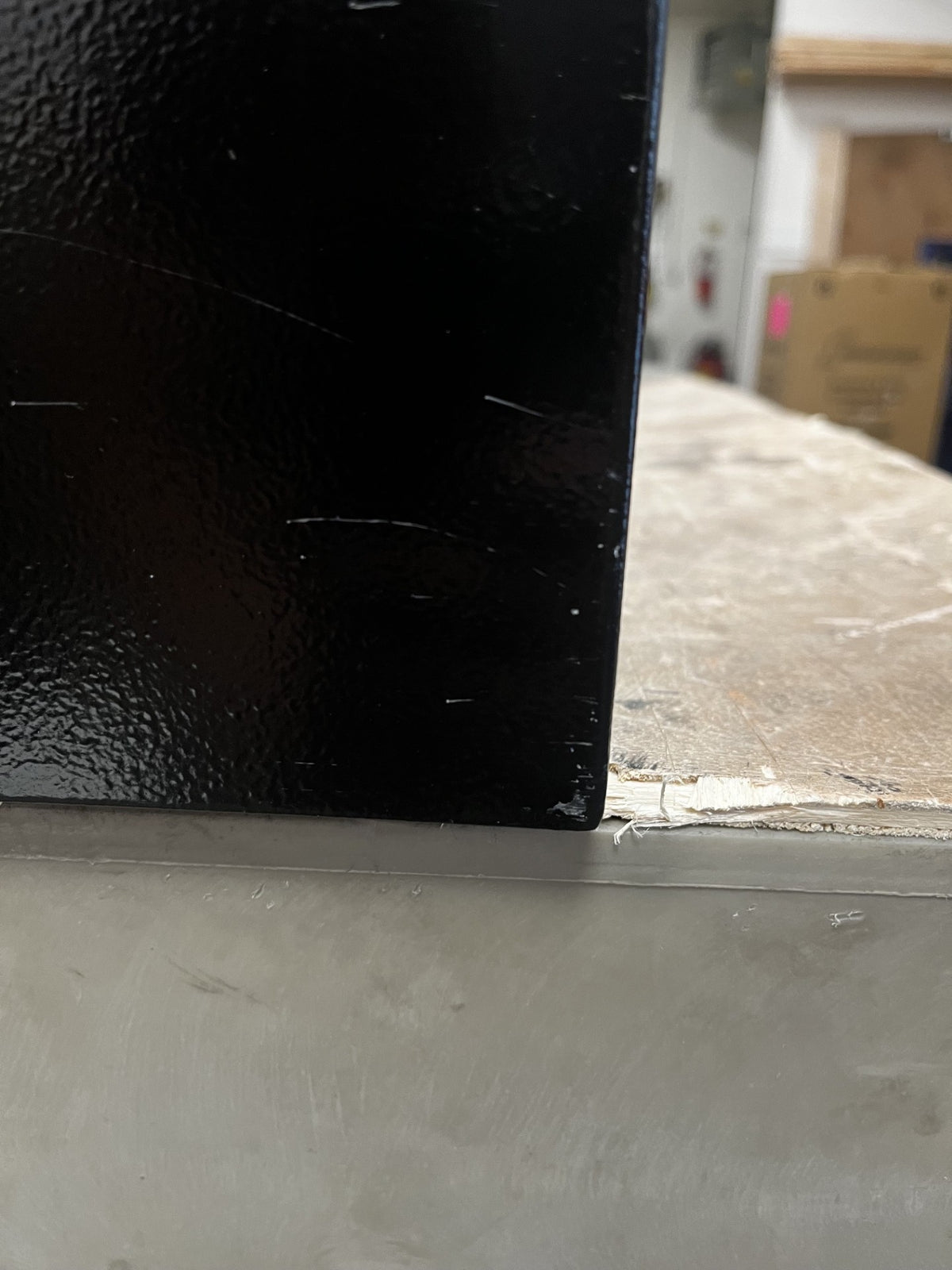 View of the right lower corner on the left side of the safe. The right corner has a few scratches on it. 