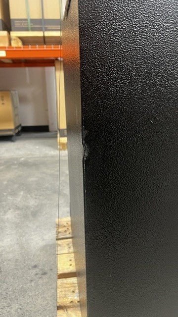 The safe has a small dent alongside the edge on the left side and back side of the safe. 