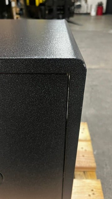 View of a small chip on the paint on the back top right corner of the safe. 