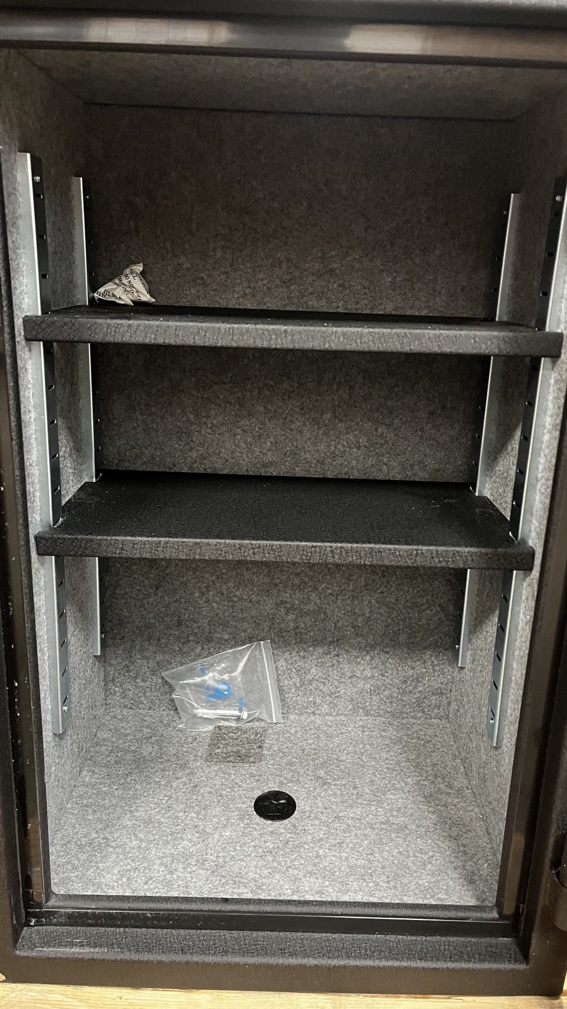 View of the inside of the safe. The safe comes with two adjustable shelfs. The shelfs are also removable. It also, has a predrilled hole in the center of the safe and the hardware is provided as well. 