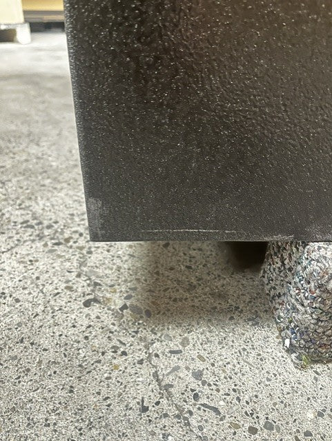 close-up view of a small scratch on the bottom left corner on the left side of the safe. 
