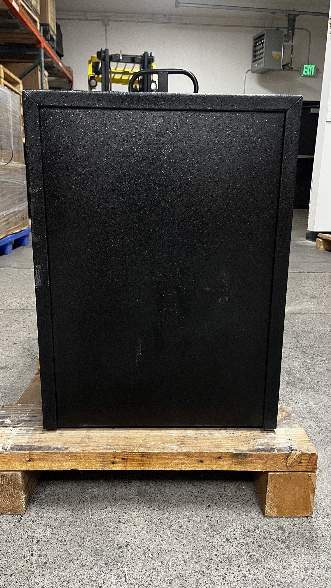 View of the back side of the safe. The lower edge has scratches going across the safe. 
