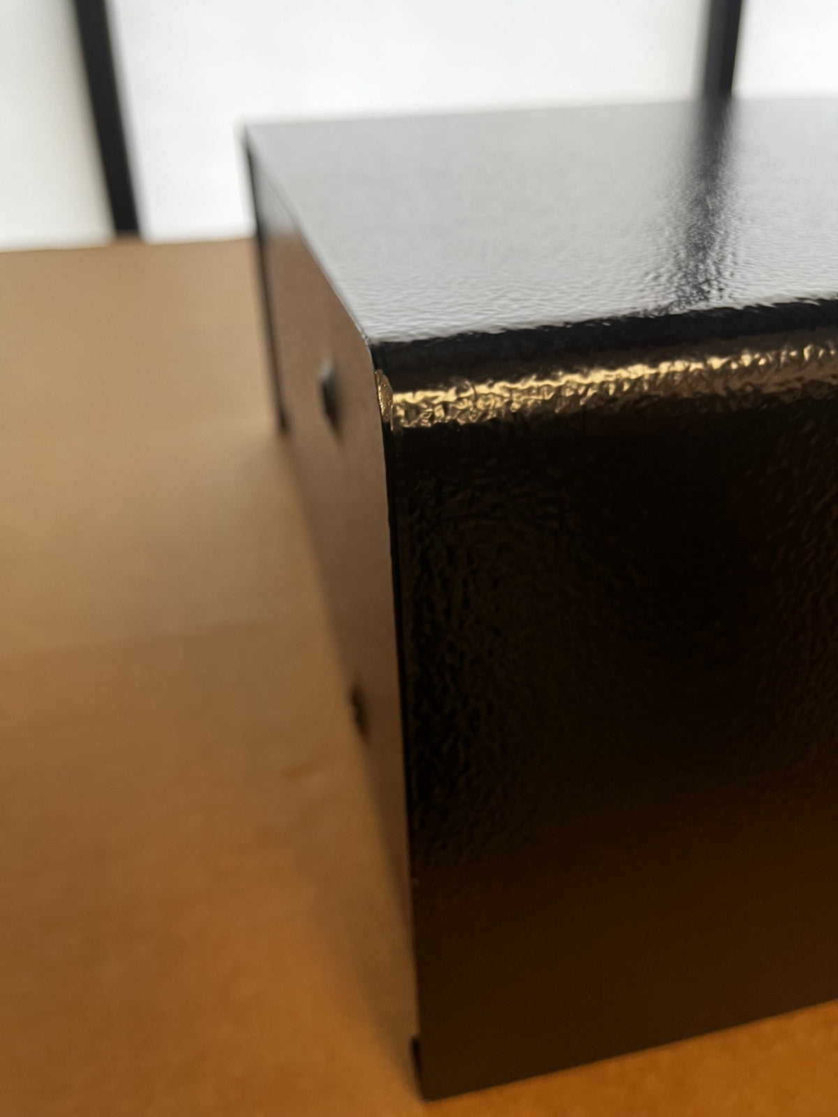 View of the top left corner on the right side of the safe. It has a small chip on the paint. 