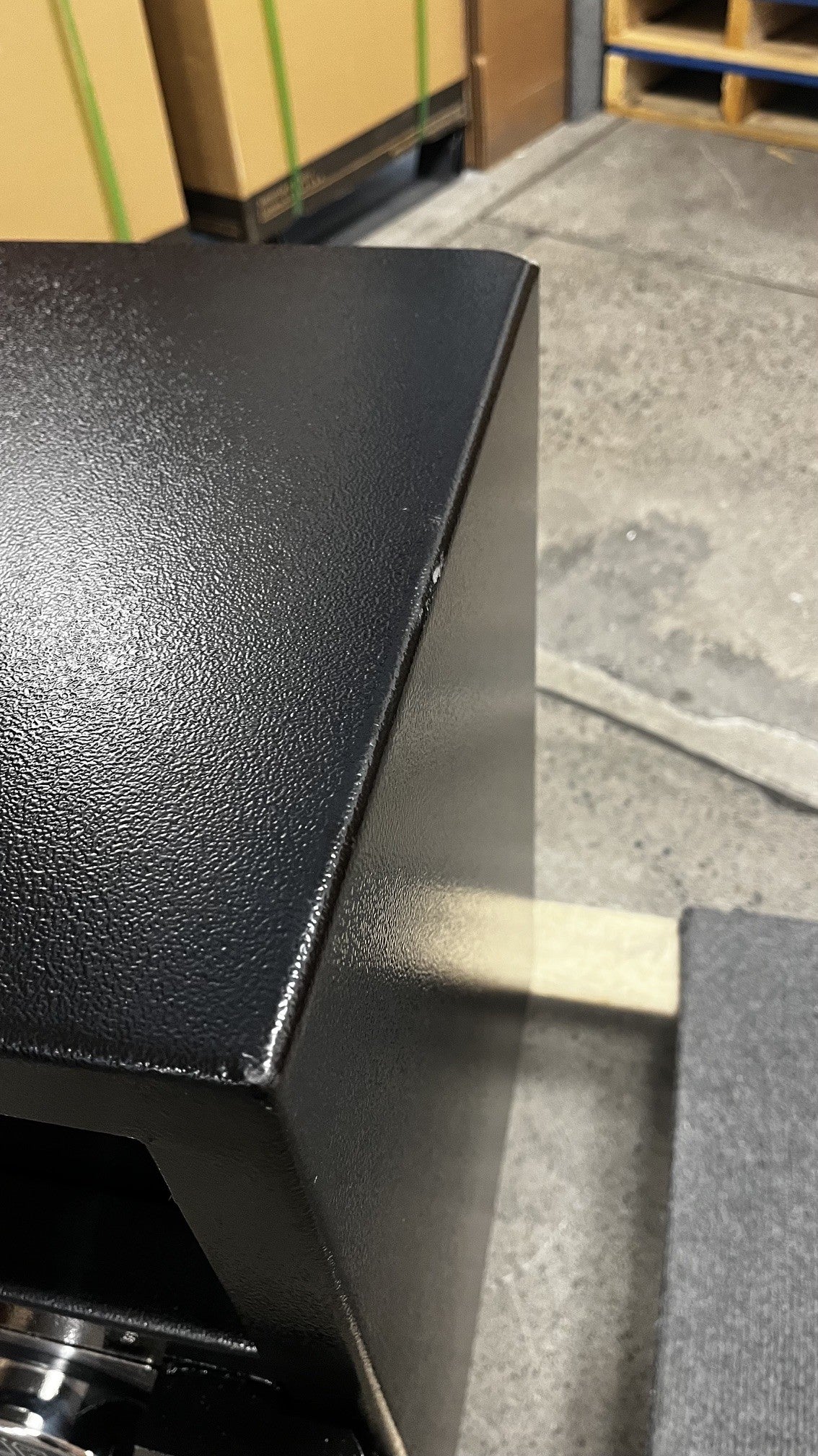 View of the front top right corner and edge. The front has a few small chips along the edge. 