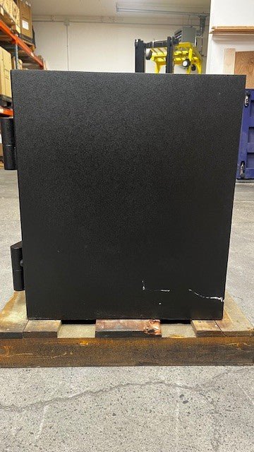 View of the right side of the safe. The safe has some scratches on the paint. 