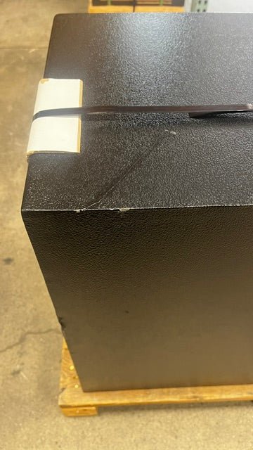 Top view of the left side of the safe. The top edge has a few paint chips, and the top of the safe has a scratch.  