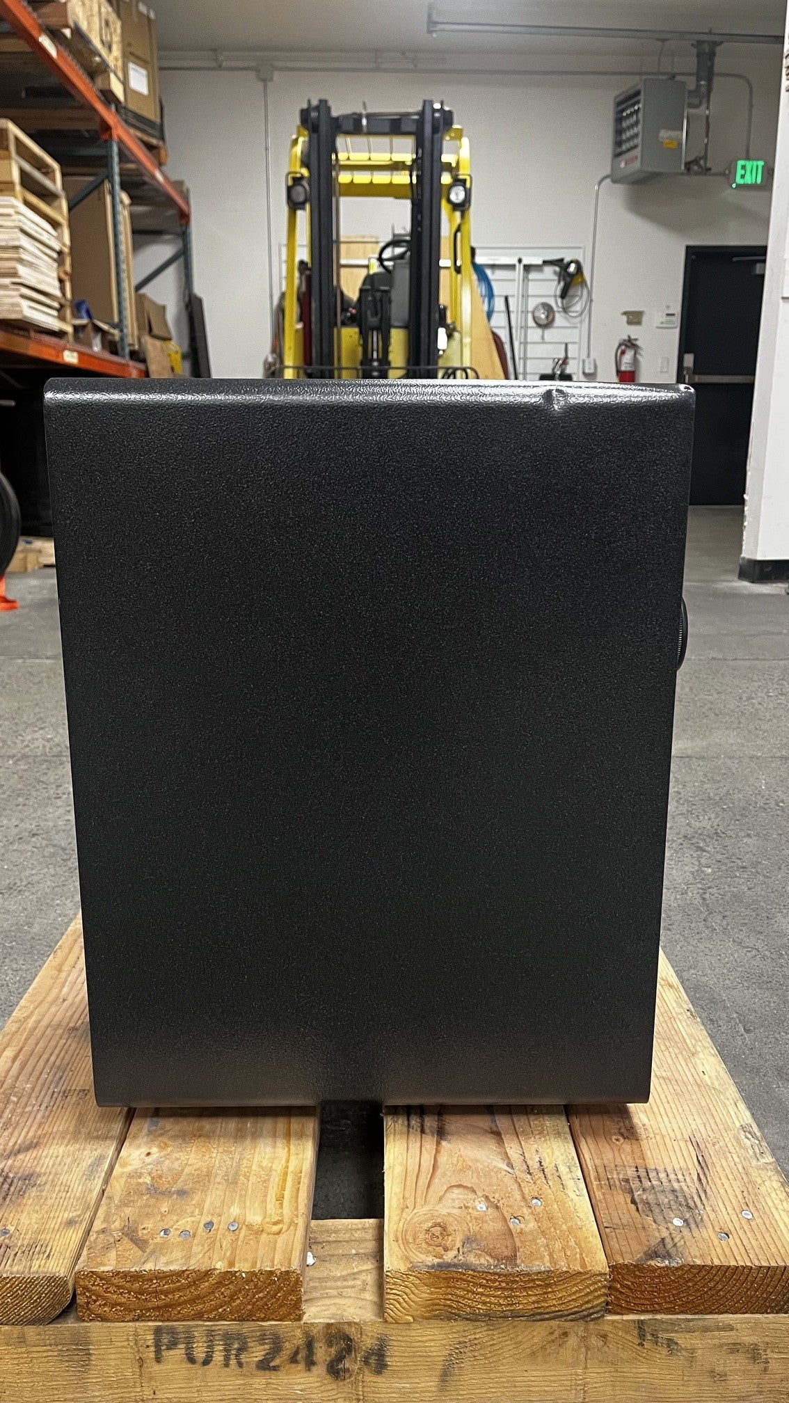 View of the left side of the safe. The safe has a dent alongside the top edge. 