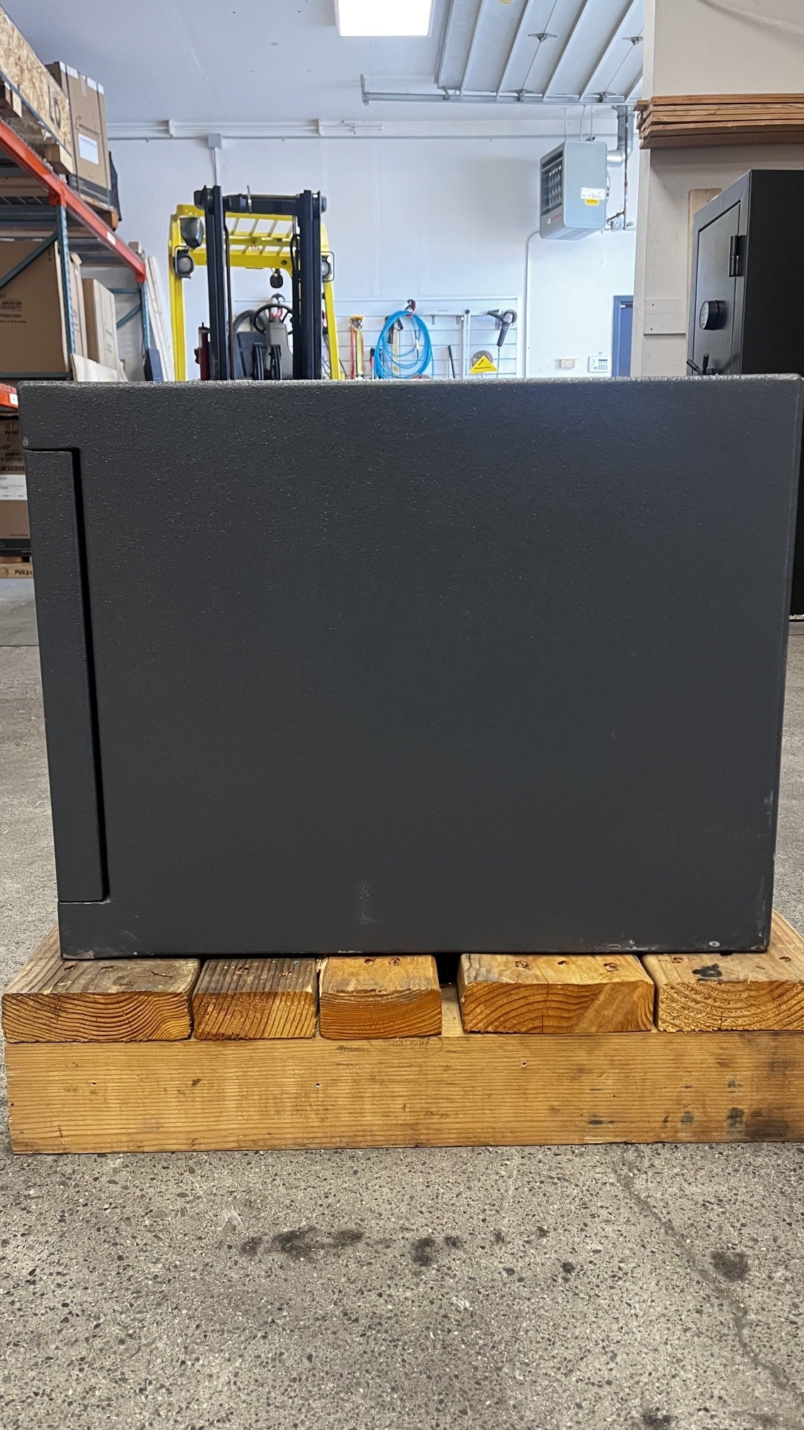 Right side view of the safe. The safe has some scratches on the lower left and right areas. 