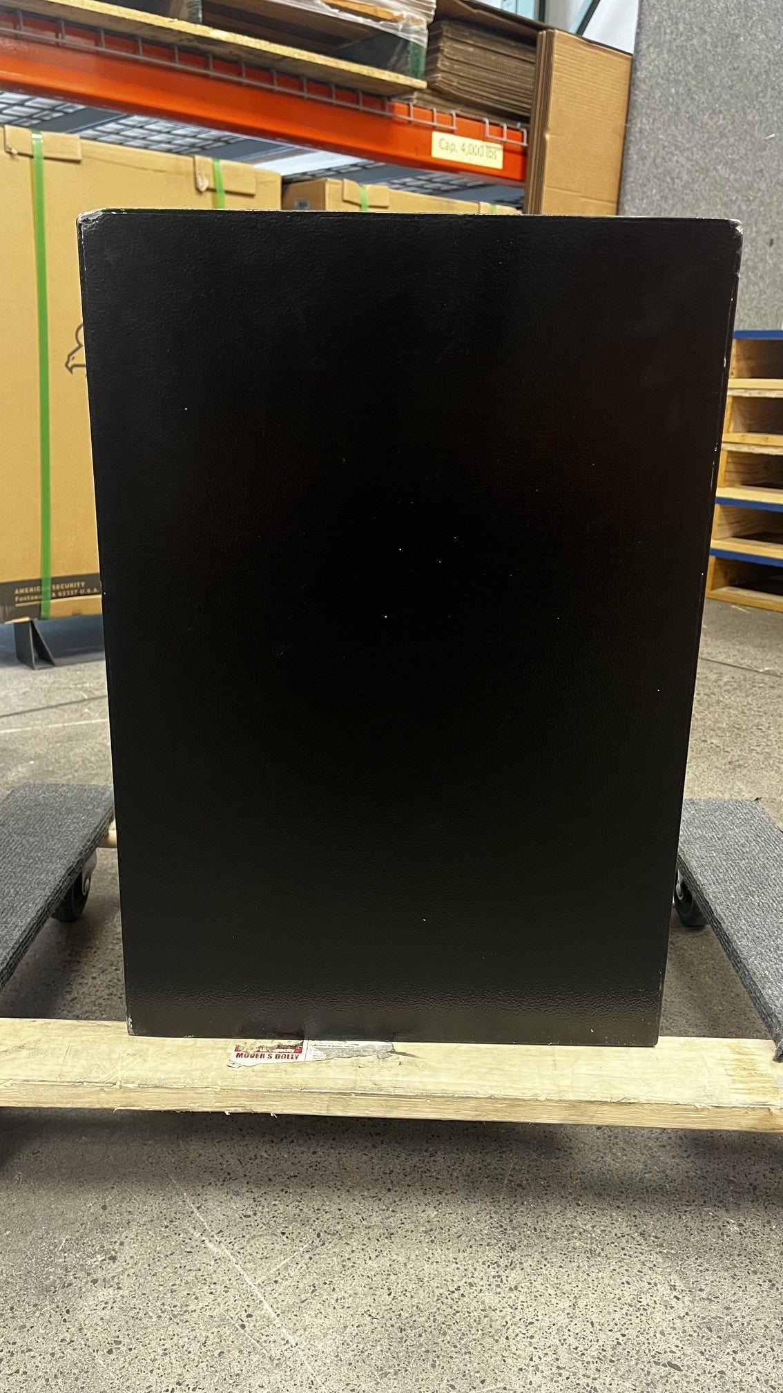 View of the back of the safe. Both bottom and top corners have chips on the paint. 