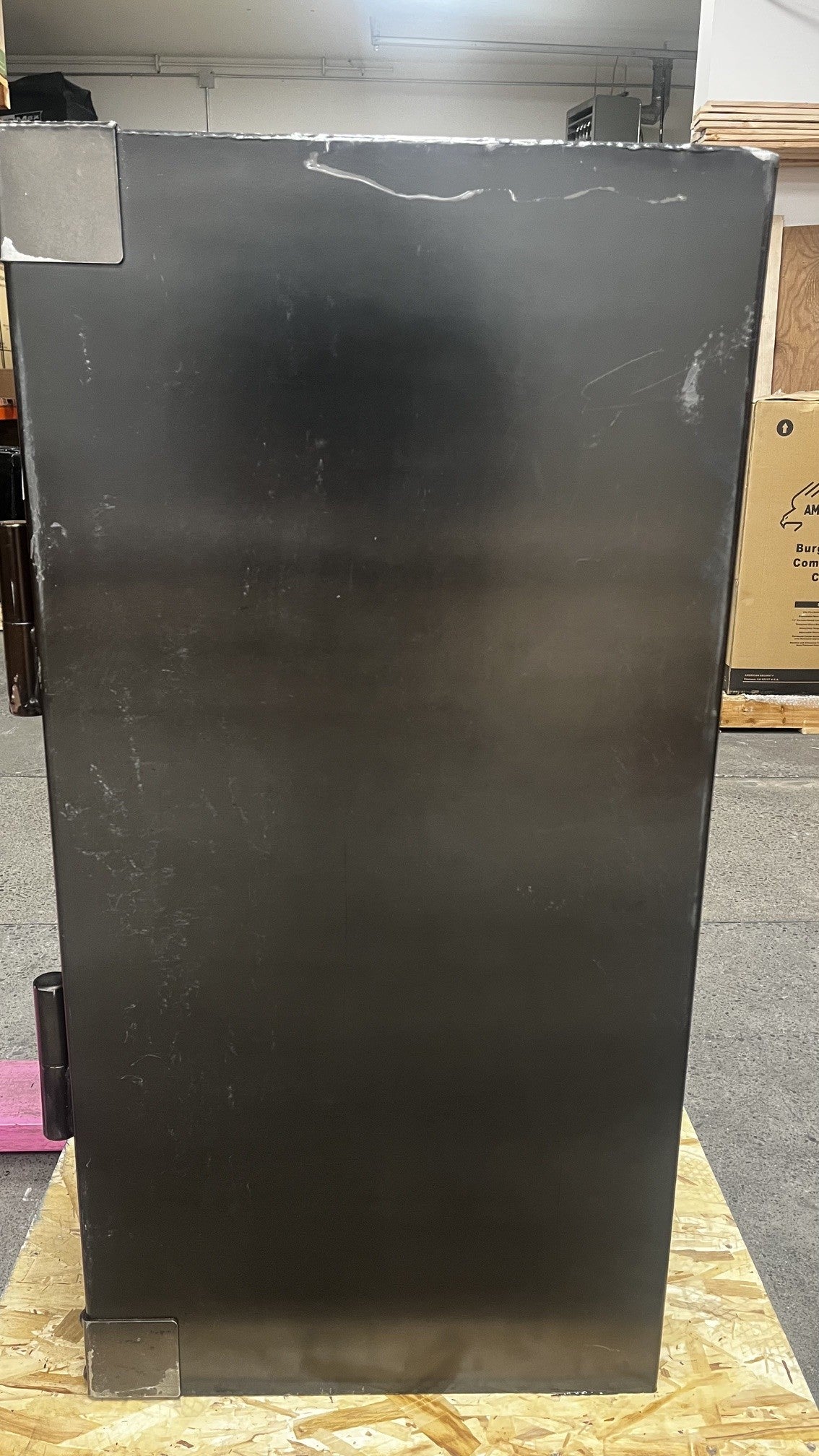 View of the right side of the safe. The safe has scratches on the body. 