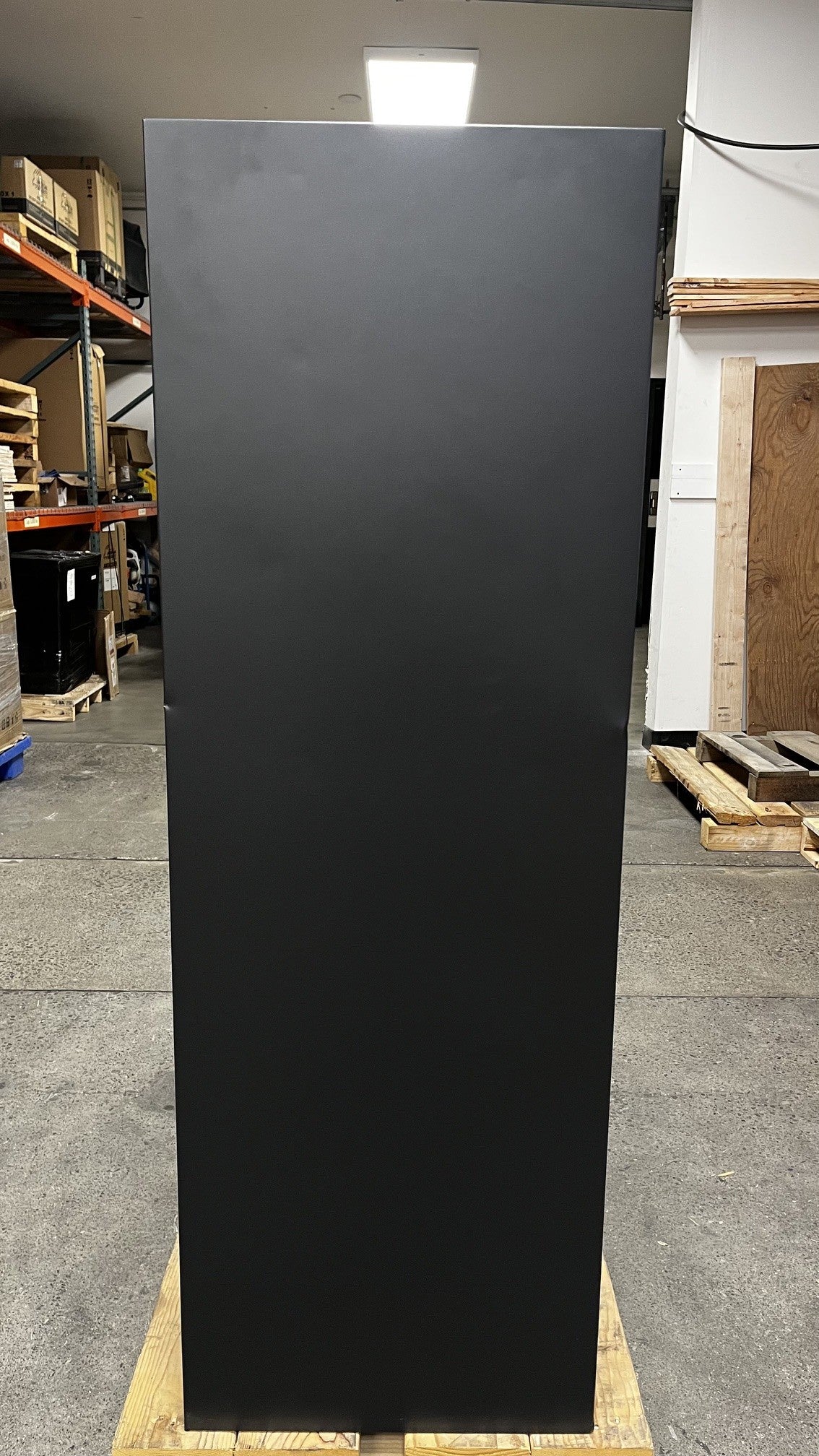 View of the right side of the safe. It has two dents on alongside the edges of the safe. 
