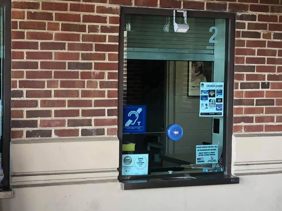 Contacta STS-K020-S23 installed at a second ticket window on a brick facade with STS-C100 microphone and hearing loop symbol