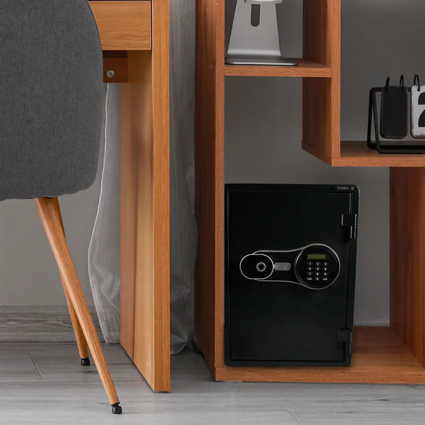 Barska AX14198 FV Pro 500 biometric fire resistant safe installed on a wooden shelf inside a home office next to a desk chair and monitor, showing typical residential placement for document and valuables storage