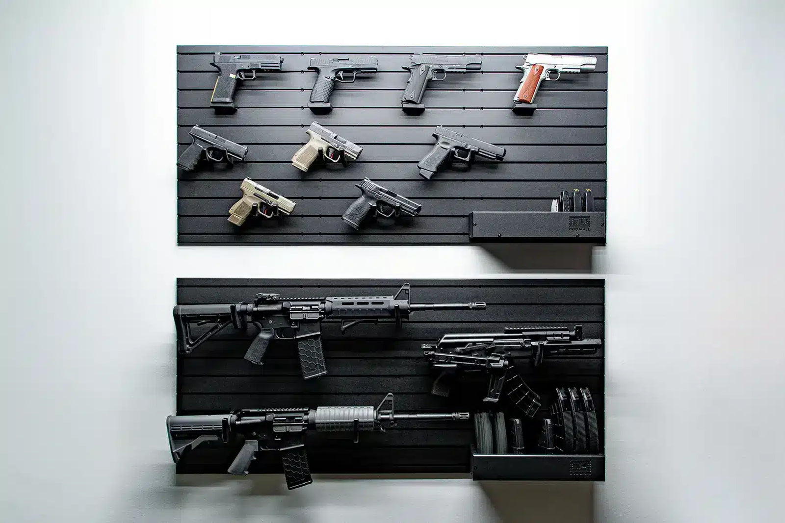 Display of various guns on a black slat wall against a white background