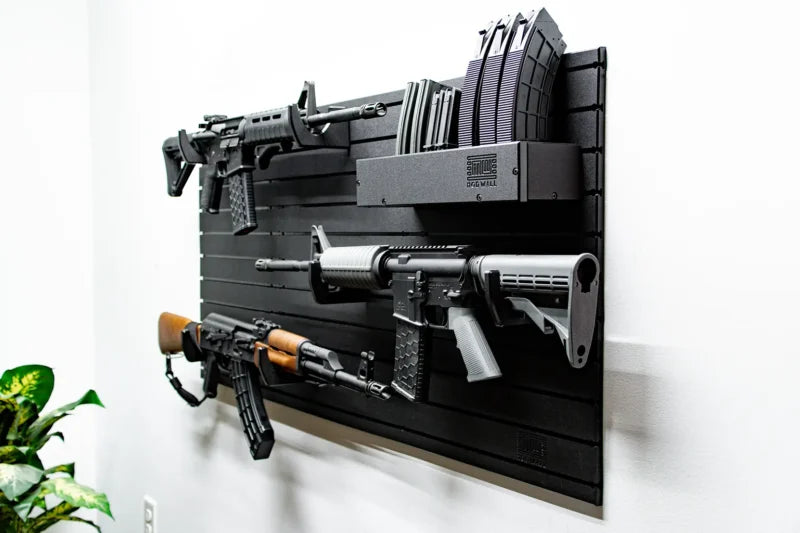 Wall-mounted gun display with various firearms on a black background