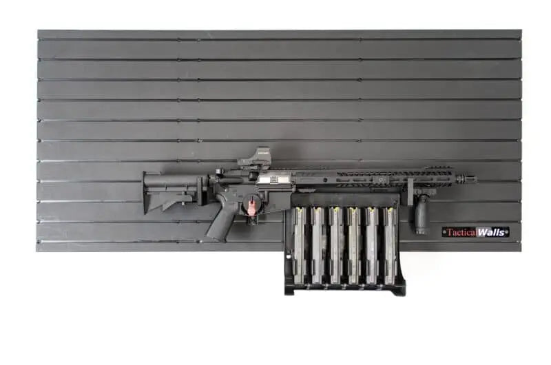 Rifle and magazines on a gray slat wall with 'Tactical Walls' branding.