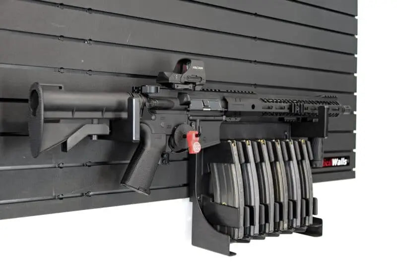 Black rifle with multiple magazines on a gray background