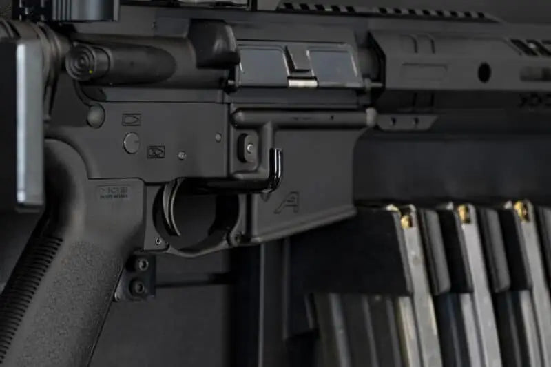 Close-up of a rifle with a magazine loaded, on a dark background
