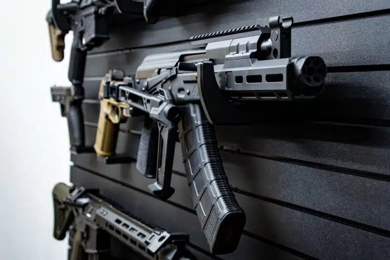 Assorted firearms displayed on a slat wall