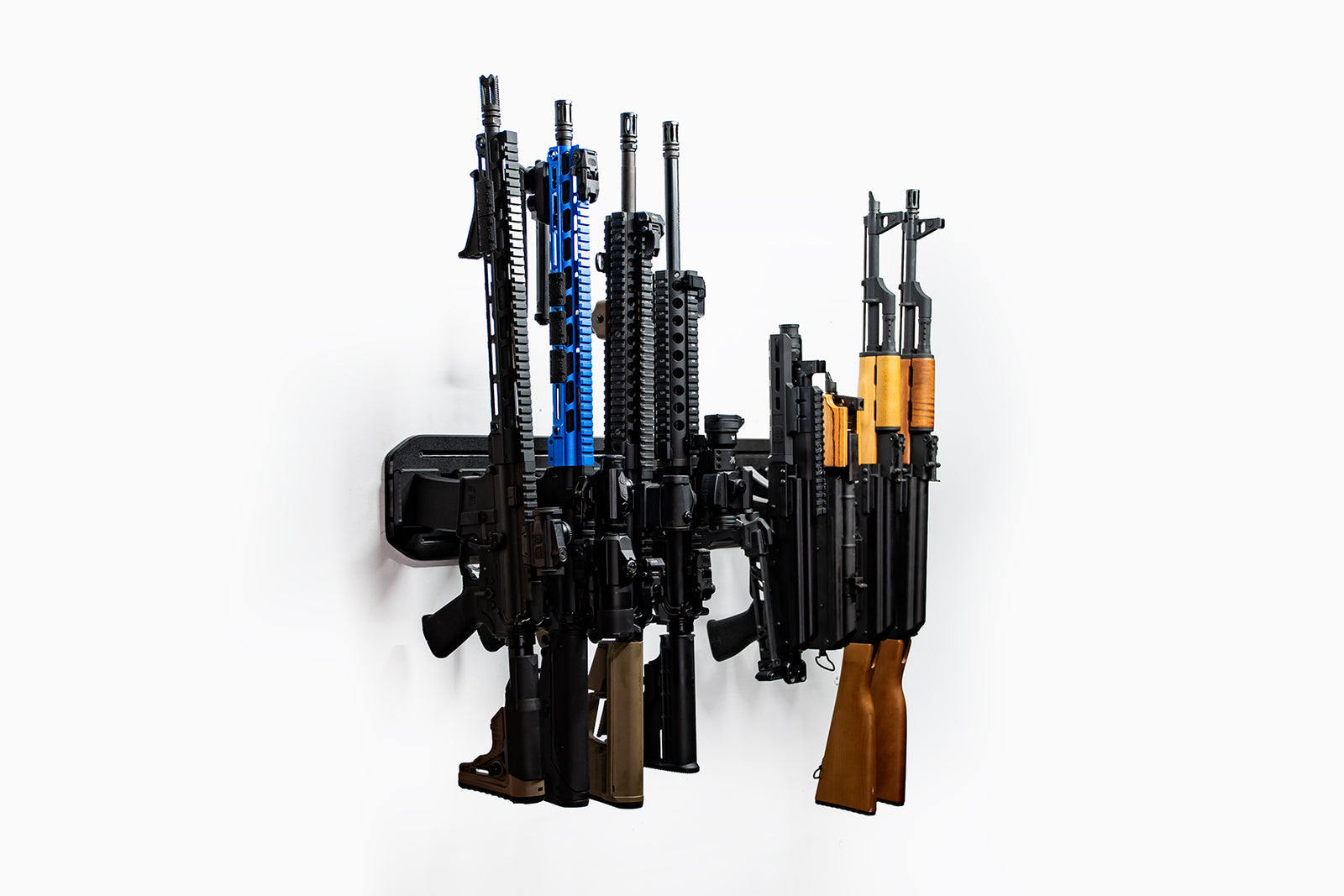 Wall-mounted gun rack holding various firearms on a white background