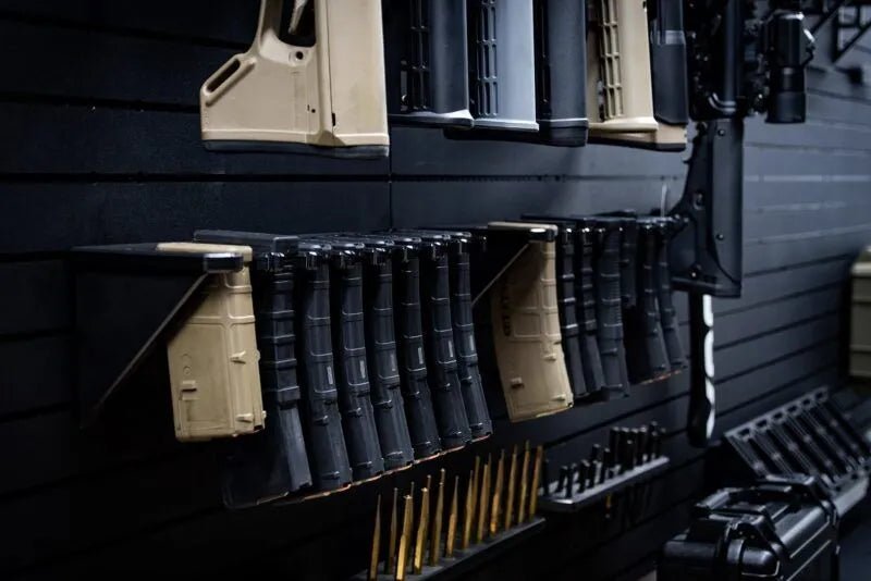 Row of rifles and ammunition on a dark surface
