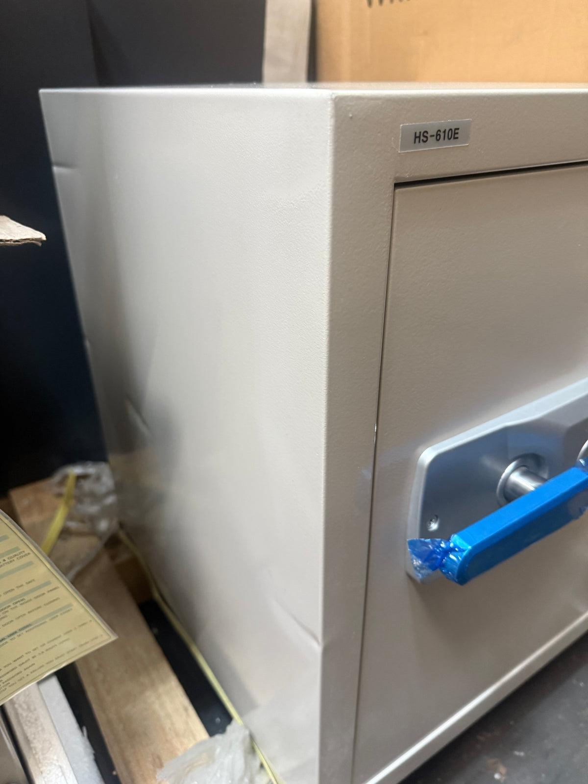 Blemished Hollon HS-610E left side of safe with a few dents and scuffs visible. 