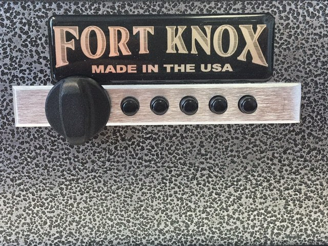 Close-up detail of the Fort Knox Auto Pistol Safe control face showing the black "FORT KNOX MADE IN THE USA" nameplate, the polished aluminum lock plate, the Simplex five-button mechanical pushbutton lock, and the black turn knob against the silver hammertone finish