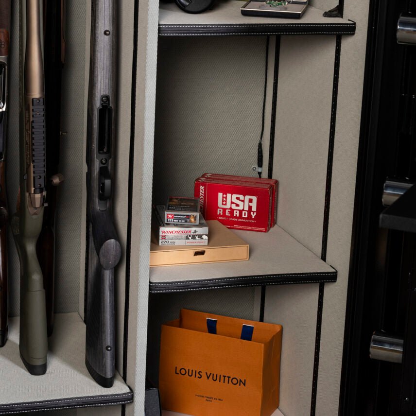 Winchester Legacy 62 interior with rifles, Winchester ammo boxes, and a Louis Vuitton bag staged as luxury valuables storage