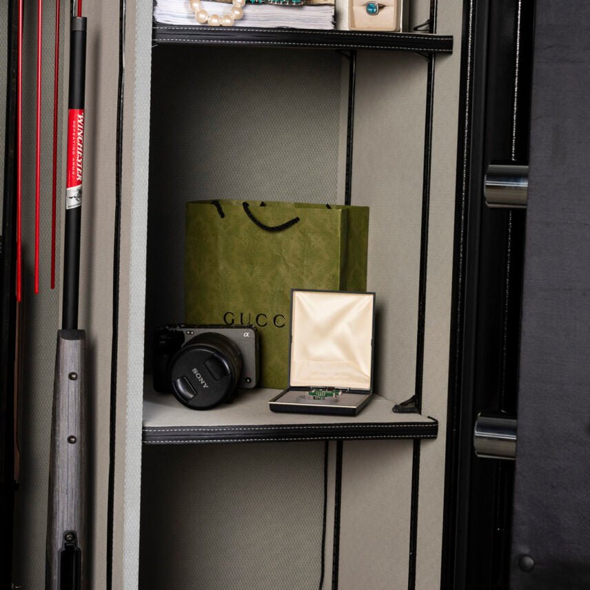 Winchester Legacy 62 interior with a Gucci bag, camera, and jewelry staged next to a wood-stock rifle in GunStiXX storage