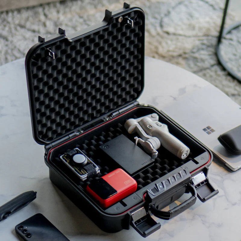 Vaultek LifePod XE on a table holding a gimbal, camera, and tech accessories for portable valuables storage