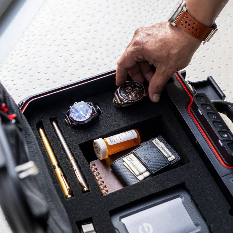 Vaultek LifePod XE interior with watches, pens, prescription bottle, wallet, and hard drive in pluck foam