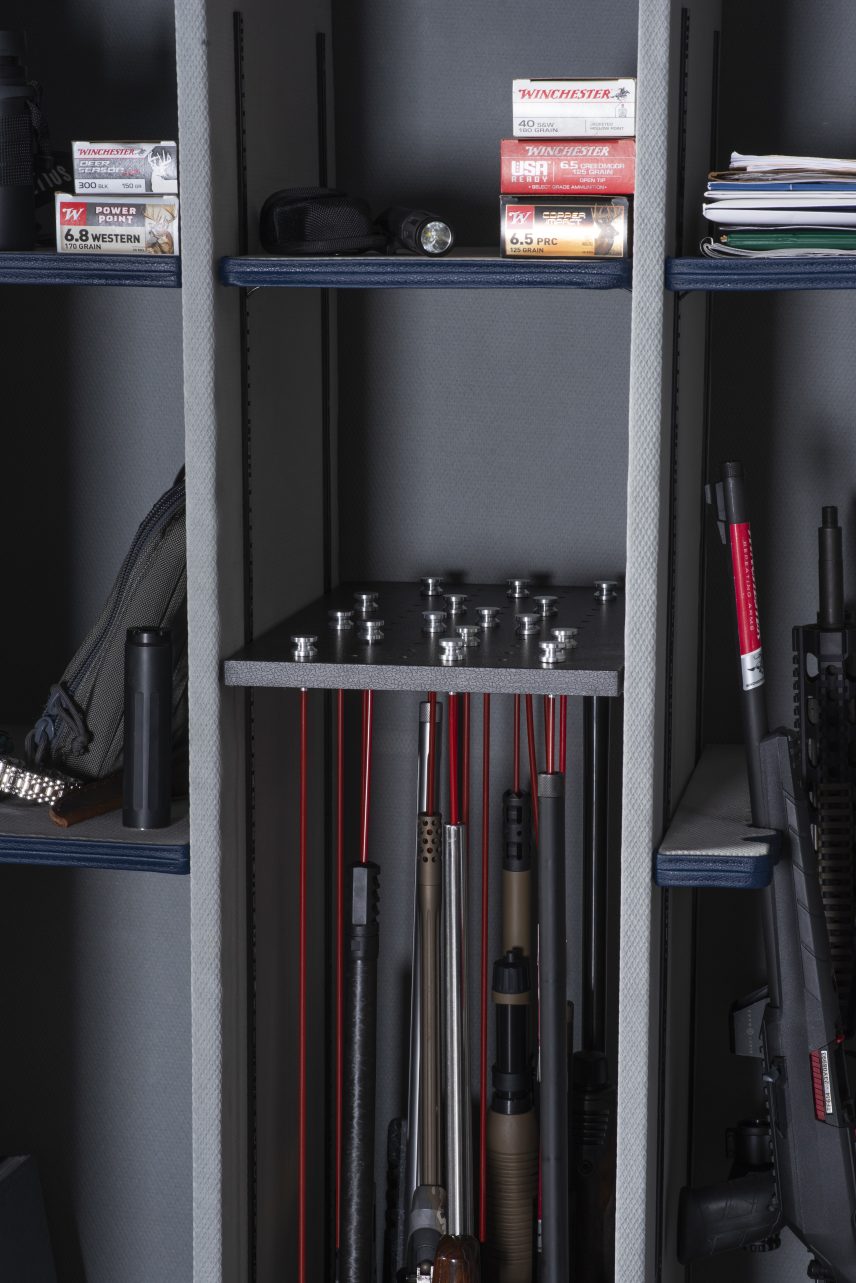 Close-up of the Winchester Outrider 41 GunStiXX plate holding rifle barrels above tactical rifles in the barrel rack