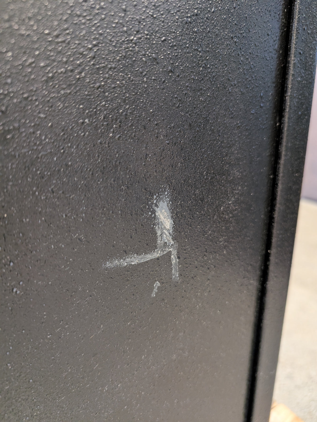 Close-up of a scratch on the body of the safe.