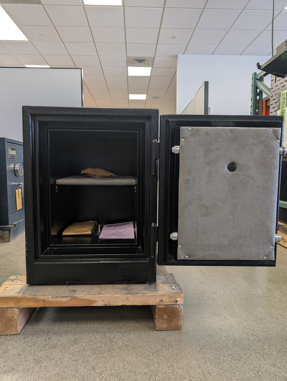 Front view of the safe with the door open. It has one adjustable shelf. 