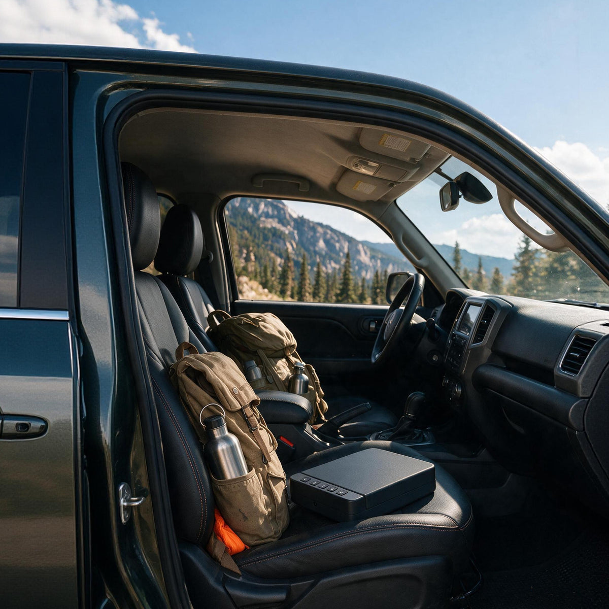 RPNB RP2019 pistol safe placed on the front passenger seat of a truck next to a backpack and water bottle, mountains outside