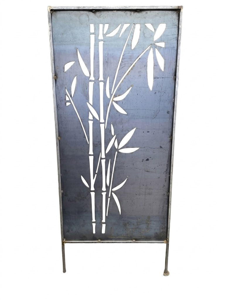 Ironman steel privacy screen freestanding outdoor garden panel in the Bamboo Grove design shown against a white background, featuring a full-height rectangular raw-steel panel with a laser-cut bamboo cluster cutout of multiple stalks and leaves framed in tubular steel, with two integrated ground stakes at the base for staking into soil