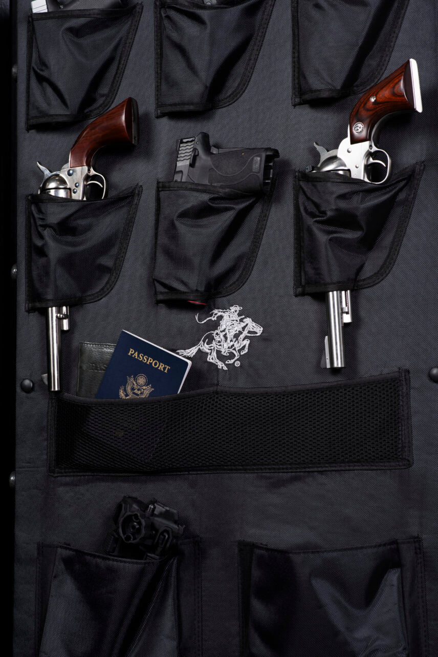Close-up of the Winchester Ranger 26 door panel organizer with revolvers, a pistol, and a passport in zippered mesh pockets