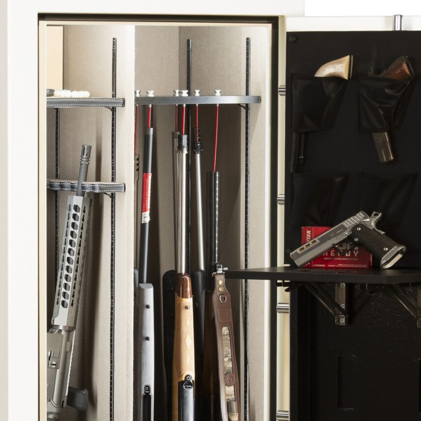 Close-up of the Winchester Ranger 26 Americana GunStiXX vertical storage system holding rifles, shotguns, and an AR-style rifle upright, with the retractable Utility Shelf visible to the right holding a handgun and ammo box
