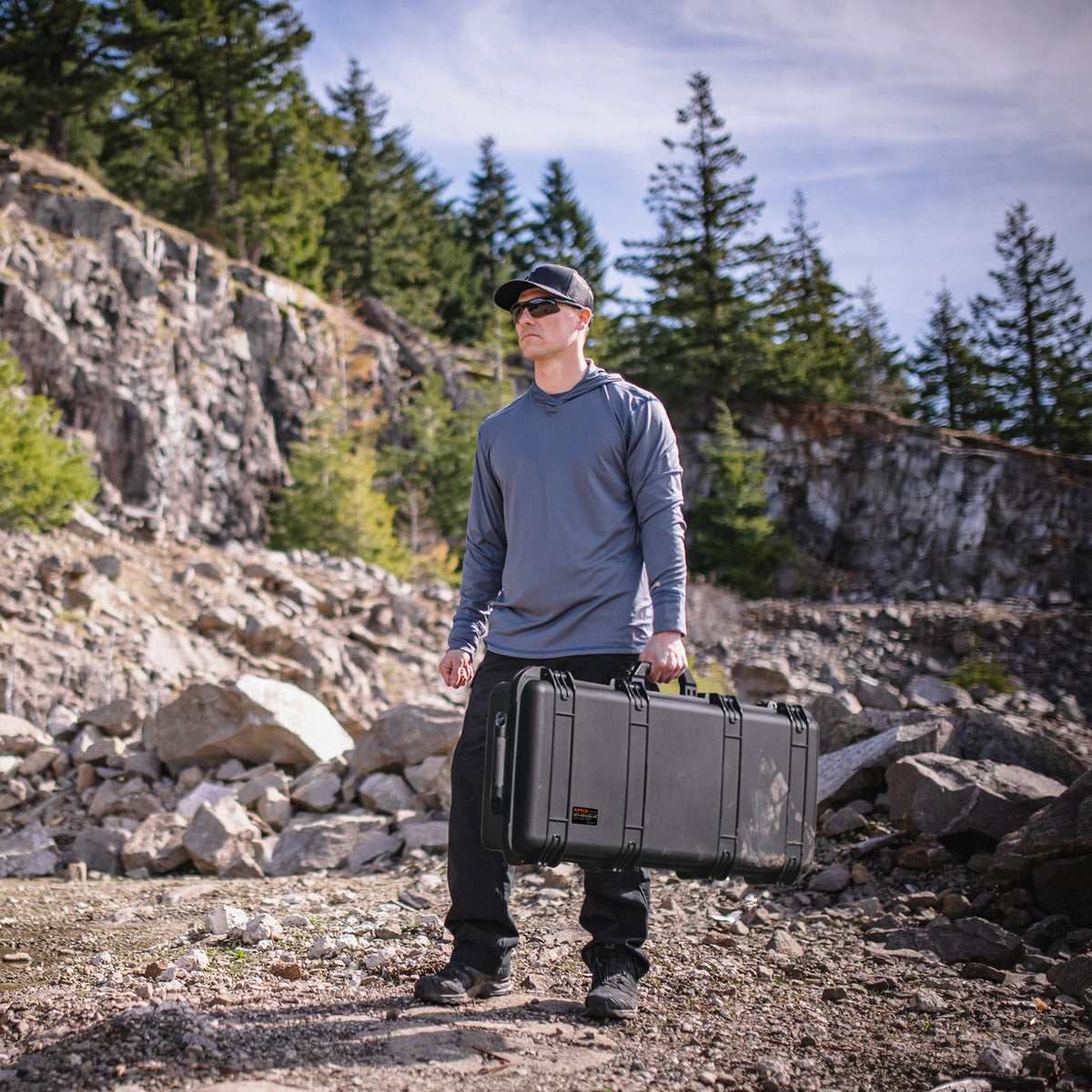 RPNB PP-12150 Weatherproof Hard Rifle Case with Customizable Foam Insert Person Carrying on Rocks