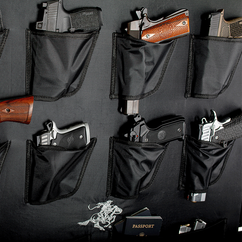 Close-up of the Winchester Big Daddy door organizer with handguns in holsters, magazine pockets, and a U.S. passport